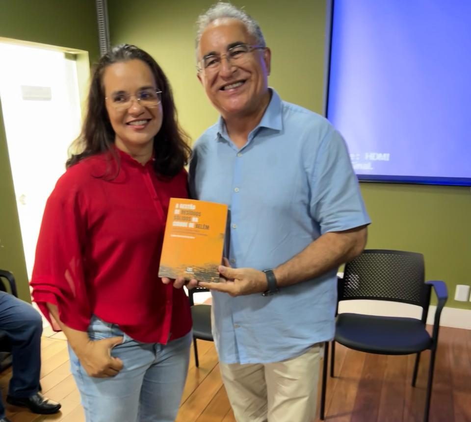 A procuradora municipal Marina Pontes entrega exemplar do livro de sua autoria ao prefeito de Belém, Edmilson Rodrigues.